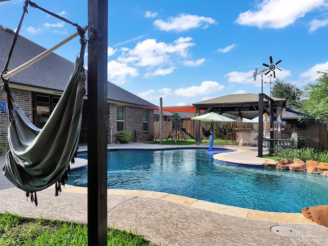 view of pool with a patio, fence, a fenced in pool, and a gazebo
