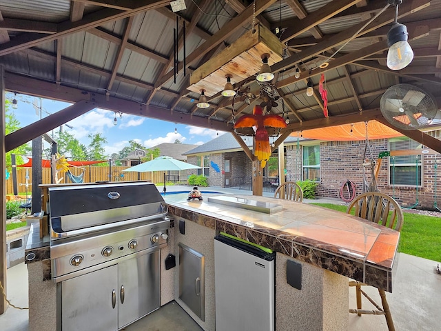 view of patio featuring area for grilling, ceiling fan, a gazebo, fence, and a grill