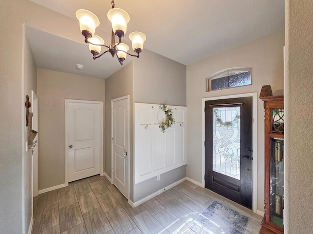 entrance foyer with baseboards, wood tiled floor, and a chandelier