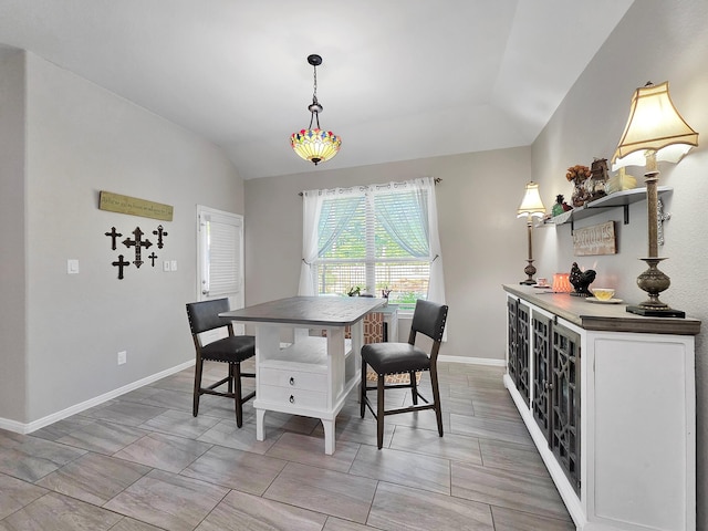 dining room featuring baseboards and vaulted ceiling
