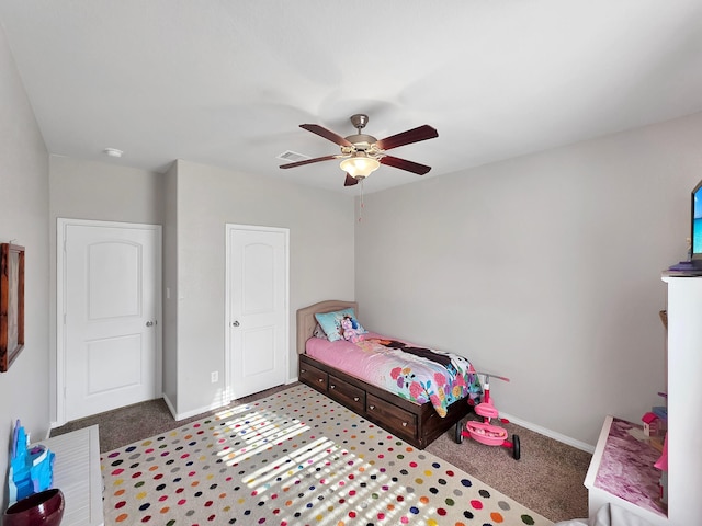 carpeted bedroom with visible vents, baseboards, and ceiling fan