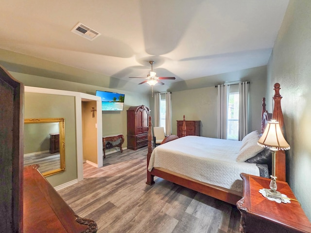 bedroom with visible vents, baseboards, ceiling fan, and wood finished floors