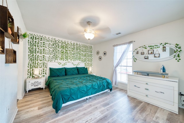 10912 Gulf Fwy Unit 28, Houston, TX 77034 - bedroom with an accent wall, baseboards, wood finished floors, and ceiling fan