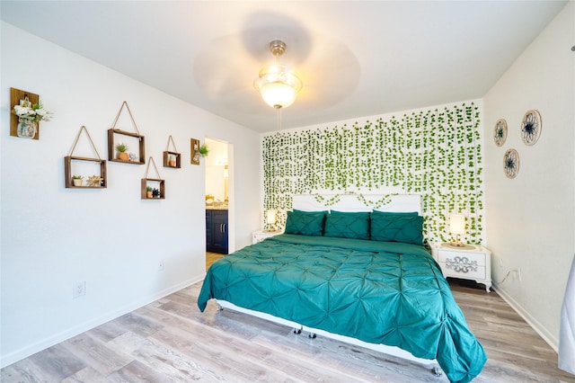 10912 Gulf Fwy Unit 28, Houston, TX 77034 - bedroom featuring wood finished floors, an accent wall, baseboards, connected bathroom, and a ceiling fan