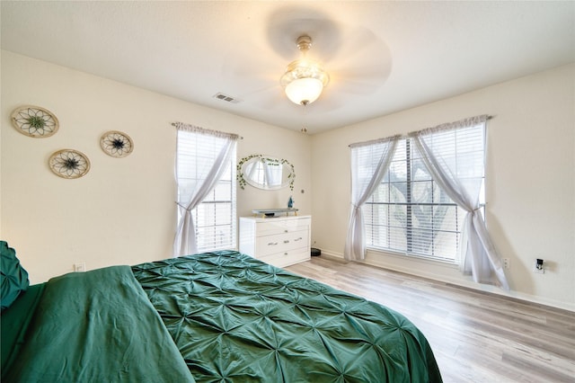 10912 Gulf Fwy Unit 28, Houston, TX 77034 - bedroom with multiple windows, light wood-type flooring, baseboards, and ceiling fan