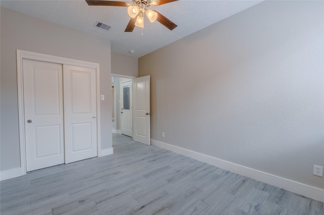 unfurnished bedroom featuring visible vents, a closet, baseboards, light wood-type flooring, and a ceiling fan