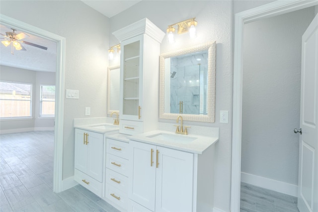 full bath featuring baseboards, a sink, wood finished floors, and a shower stall