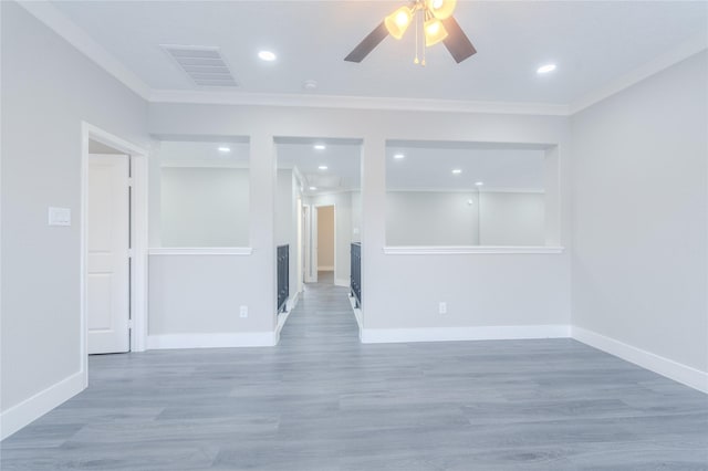 empty room featuring visible vents, a ceiling fan, baseboards, and crown molding