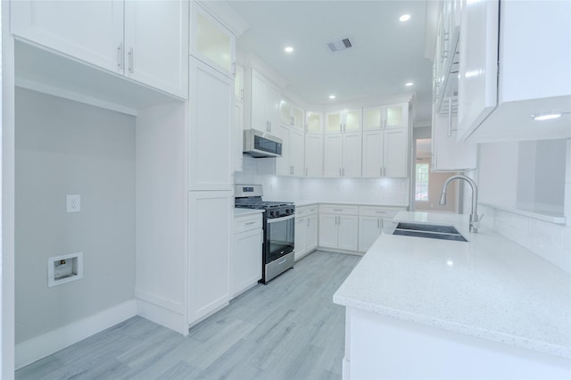 kitchen featuring appliances with stainless steel finishes, decorative backsplash, a sink, and visible vents