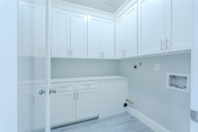 laundry room featuring washer hookup, hookup for a gas dryer, cabinet space, baseboards, and light wood finished floors