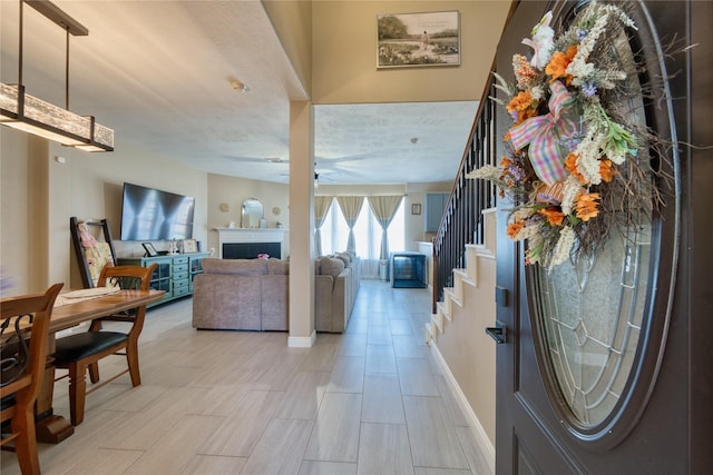 foyer featuring a ceiling fan, baseboards, and stairway