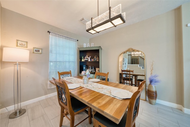 dining space with baseboards, arched walkways, and visible vents