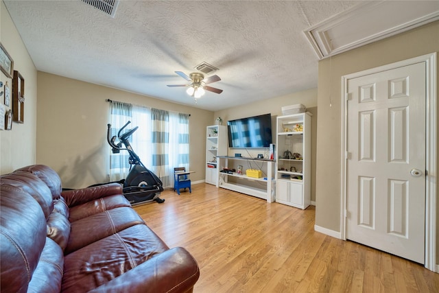 living room with visible vents, attic access, ceiling fan, a textured ceiling, and light wood-style flooring