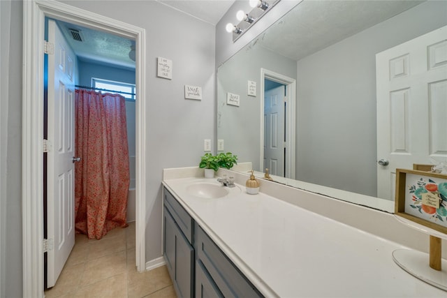 bathroom featuring visible vents, baseboards, tile patterned flooring, and vanity