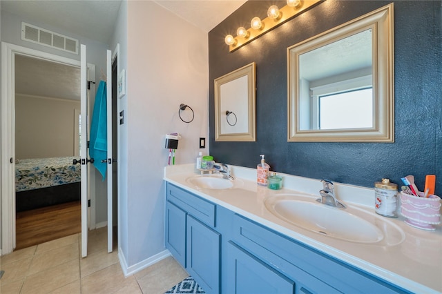 ensuite bathroom featuring tile patterned flooring, visible vents, a sink, and ensuite bathroom