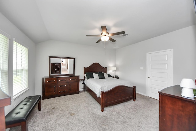 bedroom with visible vents, light carpet, a ceiling fan, and lofted ceiling