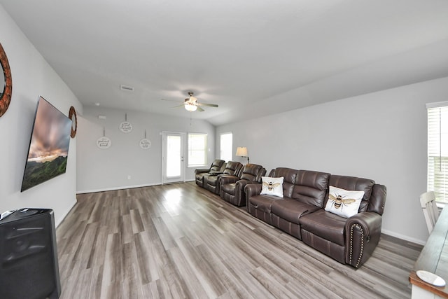 living room featuring plenty of natural light, baseboards, ceiling fan, and wood finished floors