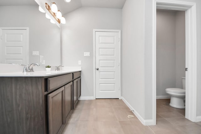 full bath featuring a sink, double vanity, tile patterned floors, toilet, and lofted ceiling