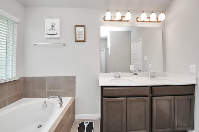 bathroom with double vanity, a sink, and a garden tub