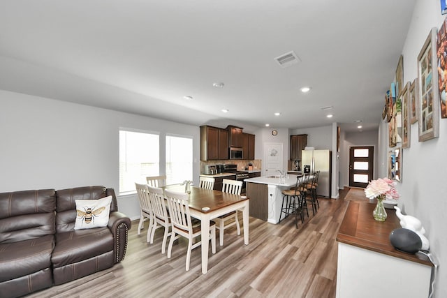 living room with visible vents, recessed lighting, baseboards, and light wood-type flooring