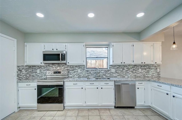 kitchen featuring a sink, appliances with stainless steel finishes, white cabinets, and tasteful backsplash