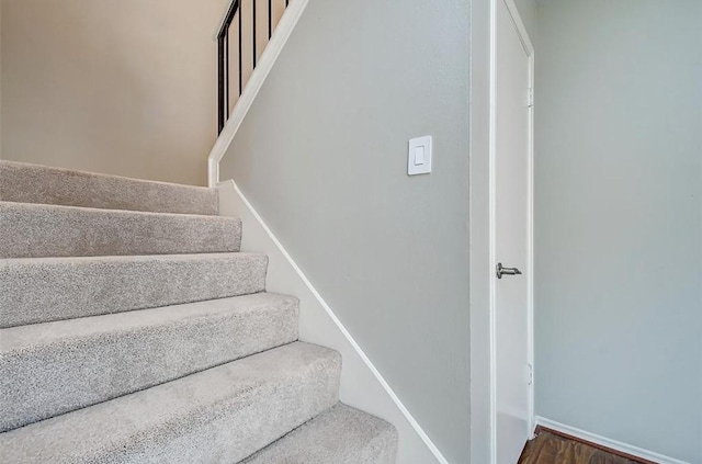 stairway featuring baseboards and wood finished floors