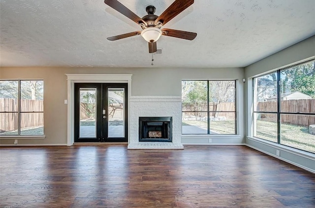 unfurnished living room with a textured ceiling, baseboards, and wood finished floors