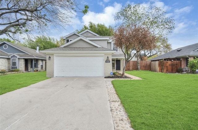 traditional home featuring a garage, fence, a front yard, roof with shingles, and driveway