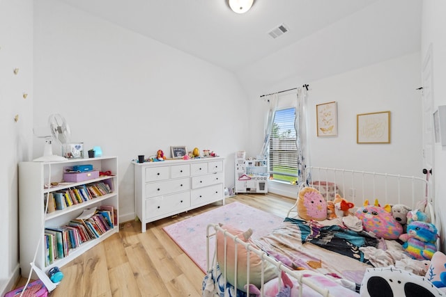 bedroom featuring visible vents, wood finished floors, and lofted ceiling