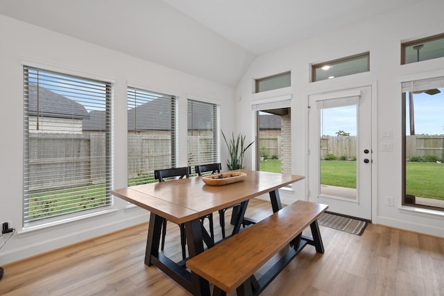interior space featuring light wood-type flooring, baseboards, and vaulted ceiling