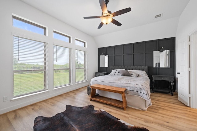 bedroom featuring visible vents, lofted ceiling, and light wood-type flooring