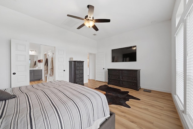 bedroom with baseboards, multiple windows, and light wood-style flooring