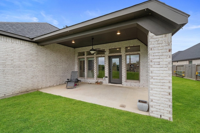 rear view of house with fence, a ceiling fan, a patio, and a lawn