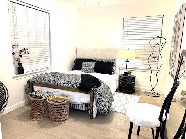 bedroom with baseboards and wood finished floors