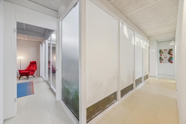 hallway featuring tile patterned floors and a drop ceiling