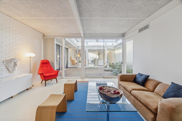 living room featuring brick wall and visible vents