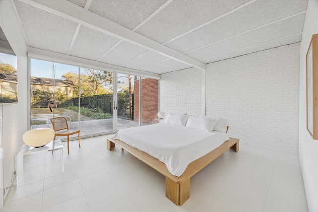 bedroom with access to outside and brick wall