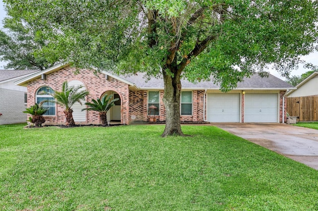 ranch-style house with fence, a front lawn, brick siding, a garage, and concrete driveway