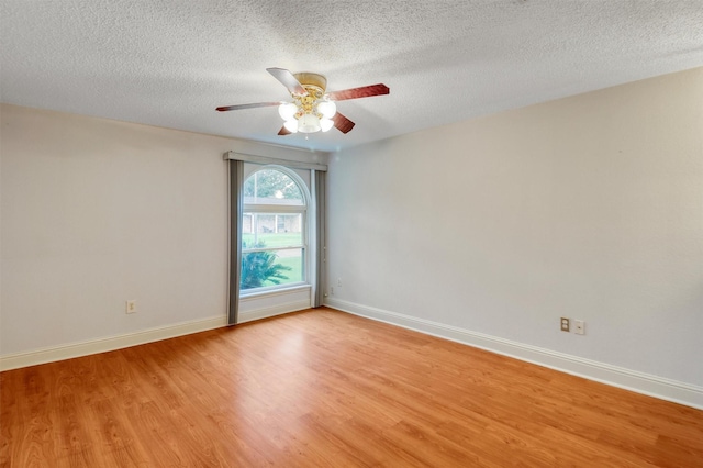 unfurnished room featuring a textured ceiling, ceiling fan, baseboards, and light wood-style floors