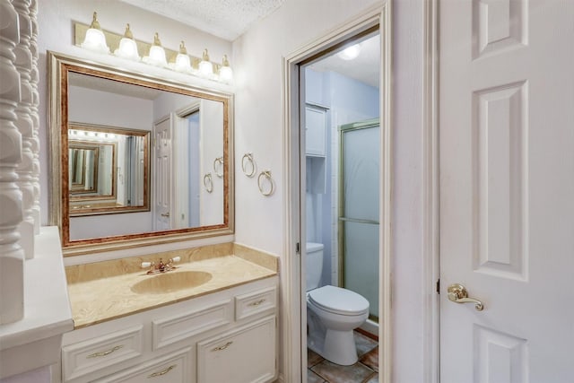 full bath featuring vanity, toilet, a textured ceiling, and a stall shower