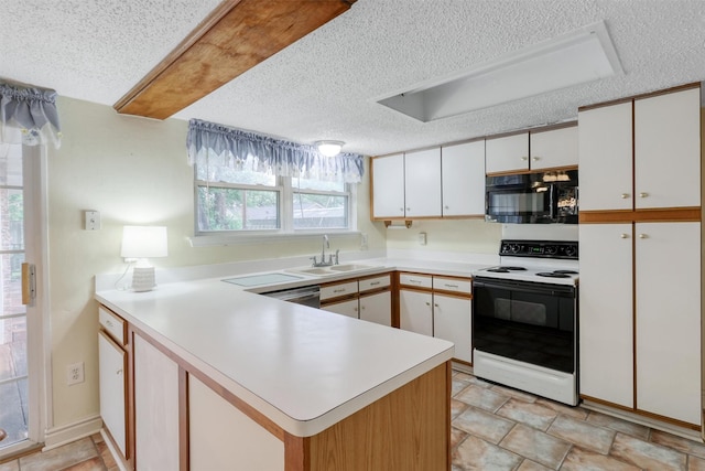 kitchen featuring a textured ceiling, black microwave, a sink, a peninsula, and electric stove