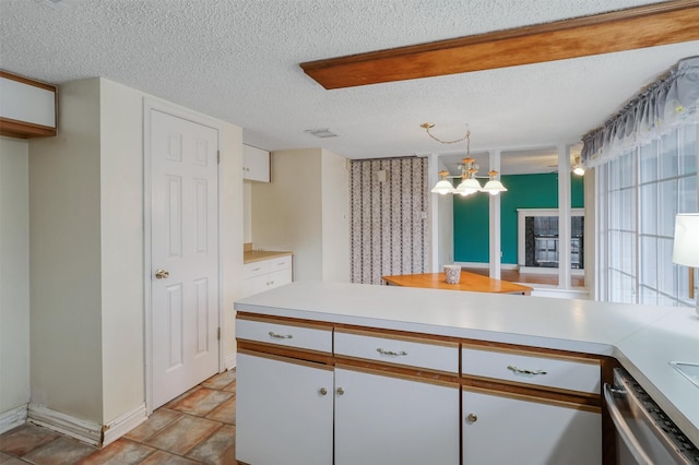 kitchen featuring stainless steel dishwasher, light countertops, a chandelier, and white cabinets