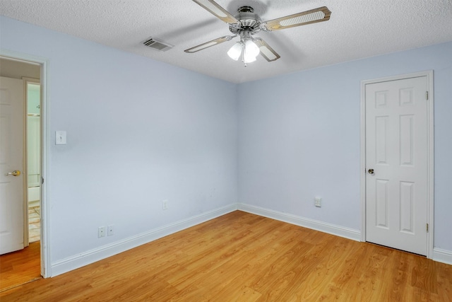 unfurnished room featuring a textured ceiling, ceiling fan, light wood-style flooring, and visible vents