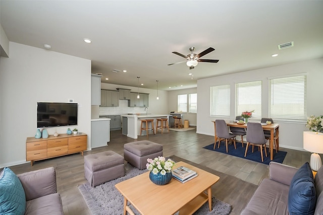 living area featuring recessed lighting, dark wood-type flooring, ceiling fan, and visible vents
