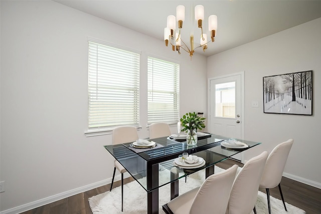 dining space featuring baseboards, dark wood-type flooring, and a notable chandelier