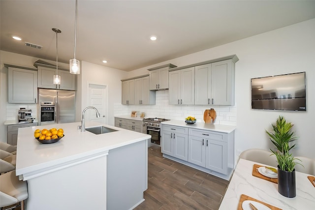 kitchen featuring stainless steel fridge, tasteful backsplash, gray cabinetry, and a sink