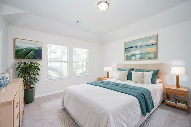 bedroom featuring baseboards, light carpet, vaulted ceiling, and visible vents
