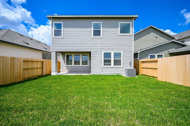 rear view of house with a lawn, a fenced backyard, a patio area, and central AC unit