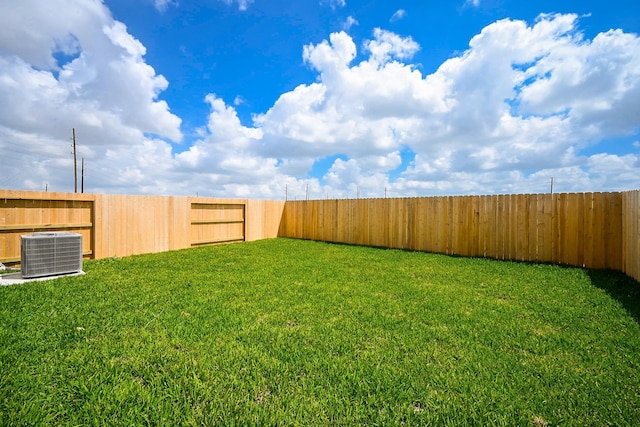 view of yard with a fenced backyard and central air condition unit