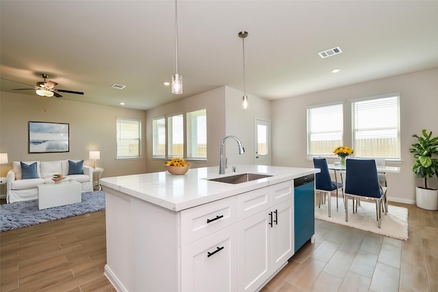 21807 Ash Cypress Ct, Cypress, TX 77433 - kitchen with a sink, dishwashing machine, pendant lighting, white cabinetry, and a kitchen island with sink